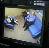 Caption: Professors Kristy Archuleta and John Grable, viewed through the monitor at their clinic., Credit: Sylvia Maria Gross