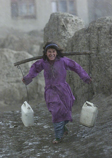 Caption: An Afghan girl carries water to her Kabul home., Credit: Associated Press.