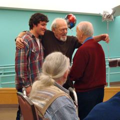 Caption: Mike Miller sings twice a week at the Hebrew Rehabilitation Center in Boston. At left is his grandson Ben.