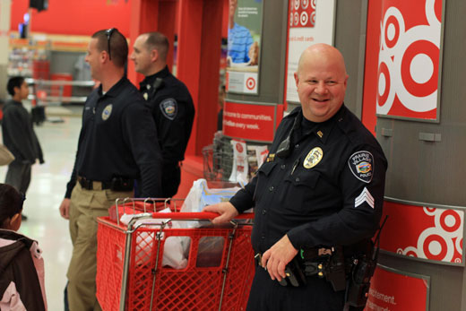 Sgt. Rod Smith shared a laugh with fellow officers as the group checked out after shopping with local kids at Target for the annual "Shop with a Cop" event.