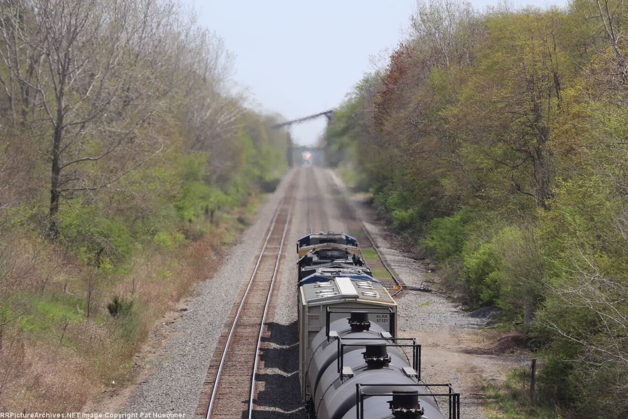 Hot exhaust from an eastbound blurs the headlight of an approaching westbound
