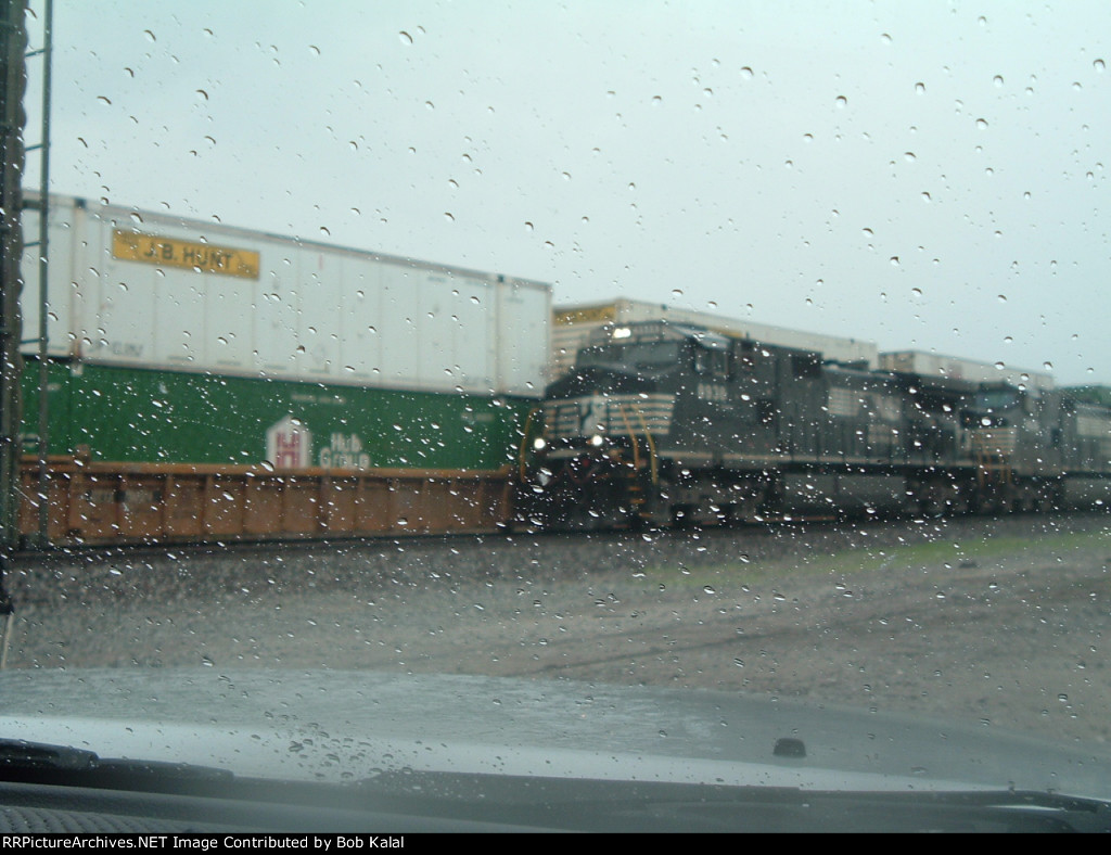 NS 8938 hooked to cars waiting for other freight train to go by  to head north