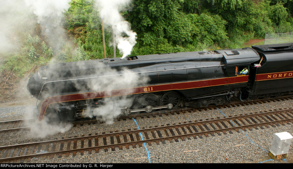 Steam swirls around the 611 as it comes to a stop below 5th St.