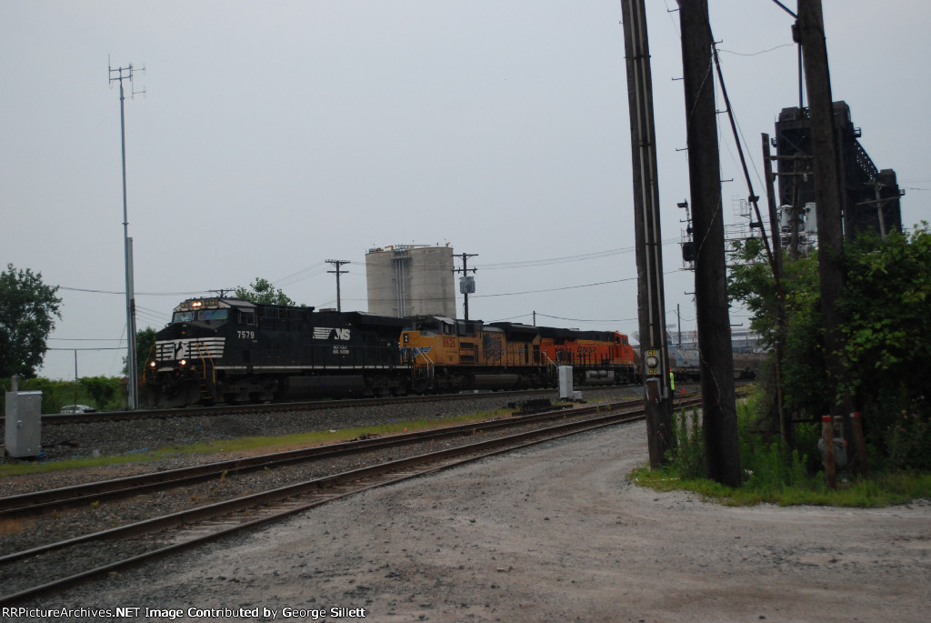 An NS, UP, BNSF lashup heads west past drawbridge.
