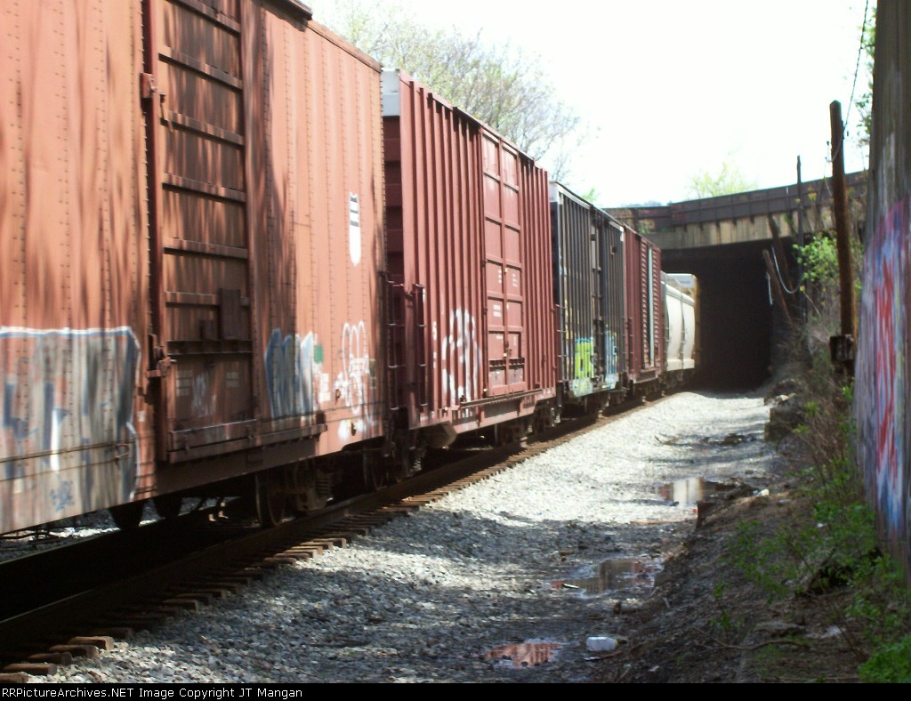 Box cars and hoppers exiting tunnel.