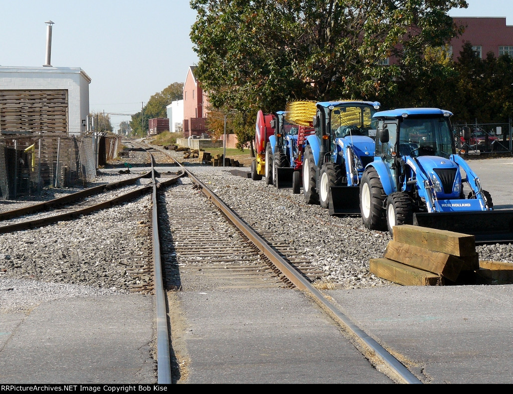 New Holland farm equipment aside the tracks, looking west
