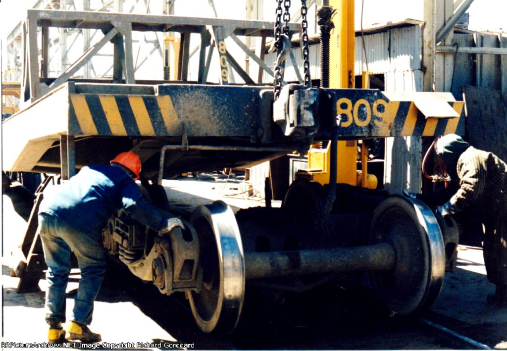 Brand new wheels going under a flat car 