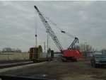 Manitowoc Crane unloading flatcar of BIG metal rings of some sort