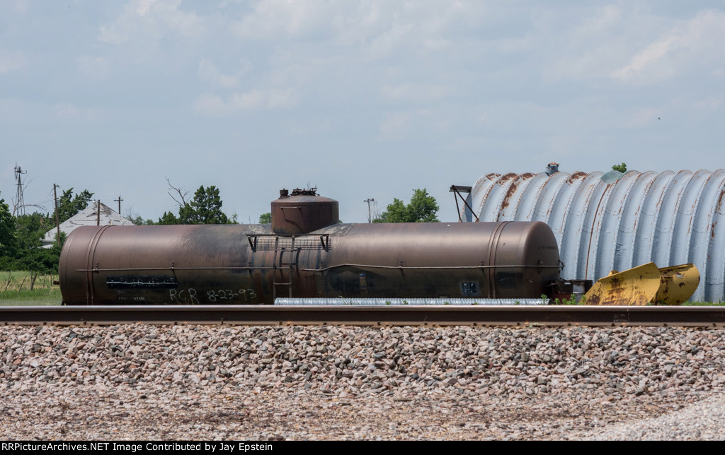 An old tank car rests by the tracks 