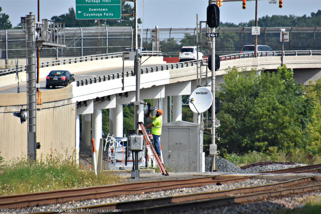 Maintainer cleans the lenses on the crossing lights.