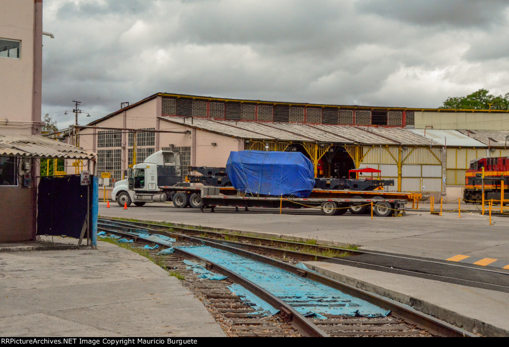 KCSM Roundhouse, prime mover and trucks on flat beds