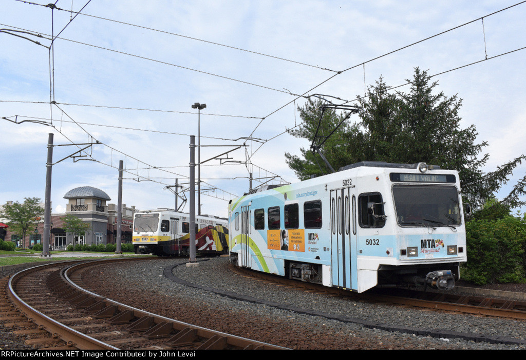 A southbound light rail train departs Hunt Valley Terminal on the right.