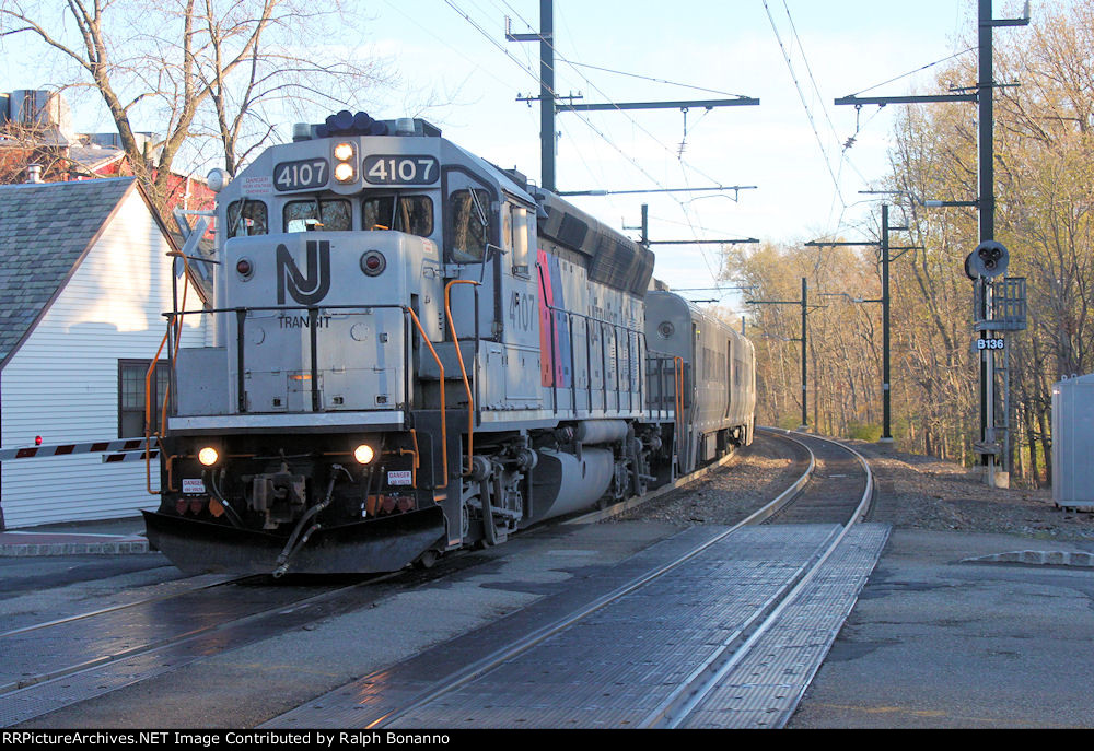 Though the shadows have overtaken, former CNJ GP40P(as built) leads an express west through town