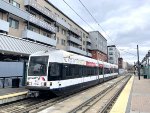 Kinki-Sharyo Car # 5006B is about to pause at 22nd Street Station with its consist. Modern development towers on the right.