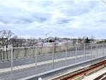 This view from the 8th Street platform is looking toward Staten Island. In the middle of the picture in the background is the Bayonne Bridge which connects the namesake city over the Kill Van Kull with Port Richmond, Staten Island.