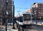 An eastbound light rail train gliding into the Essex Street Station 