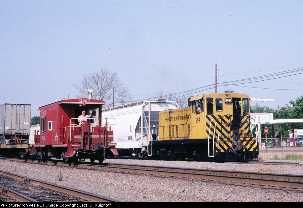 Prescott & Northwestern 24 is interchanging with the MP as a w/b MP caboose 13067 passes