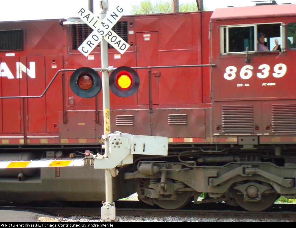 Engineer of CP 8639 gives a wave as he crosses Peterson Road