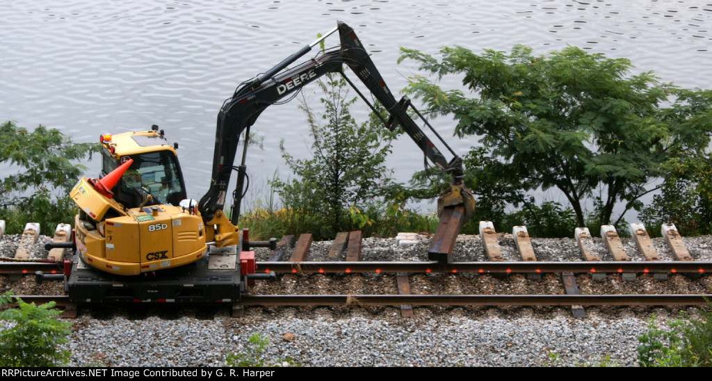 Tie grabber sets wood ties into place next to red dots to be inserted under the rails