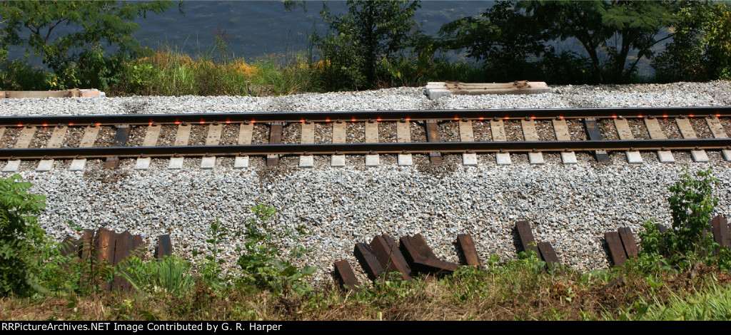 Marks made on rail where wood ties will go.  Five wood ties for every four concrete