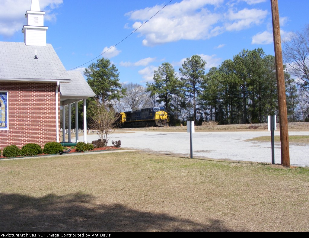 CSX 524 passes a little church