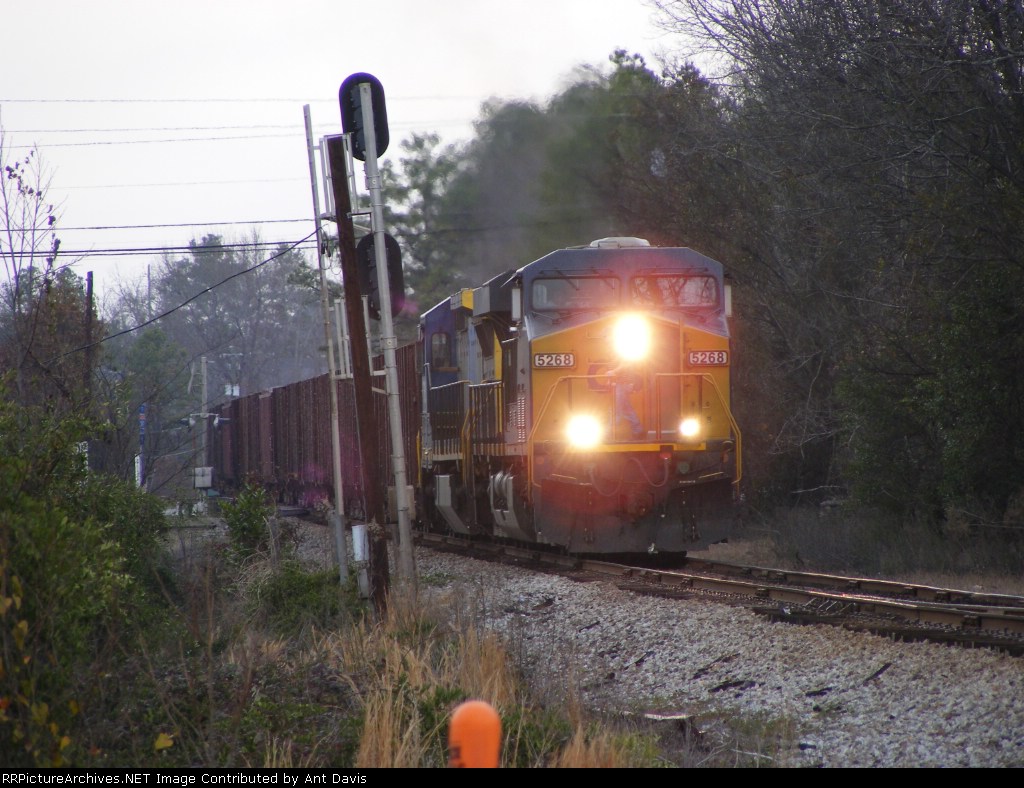 A Herzog rock train passes the "Leaning Signals of Grovetown"