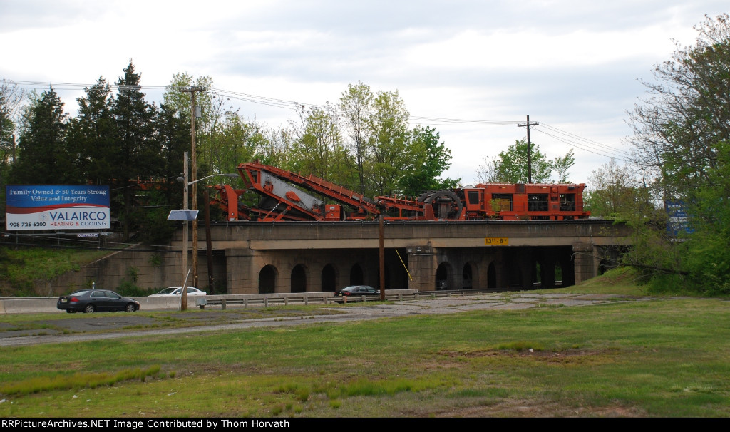 SOU 992606 is a ballast cleaner passing over Route 206 on the LEHL