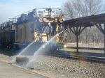 Two workers put out a fire from the water caboose.  Check out the rainbow