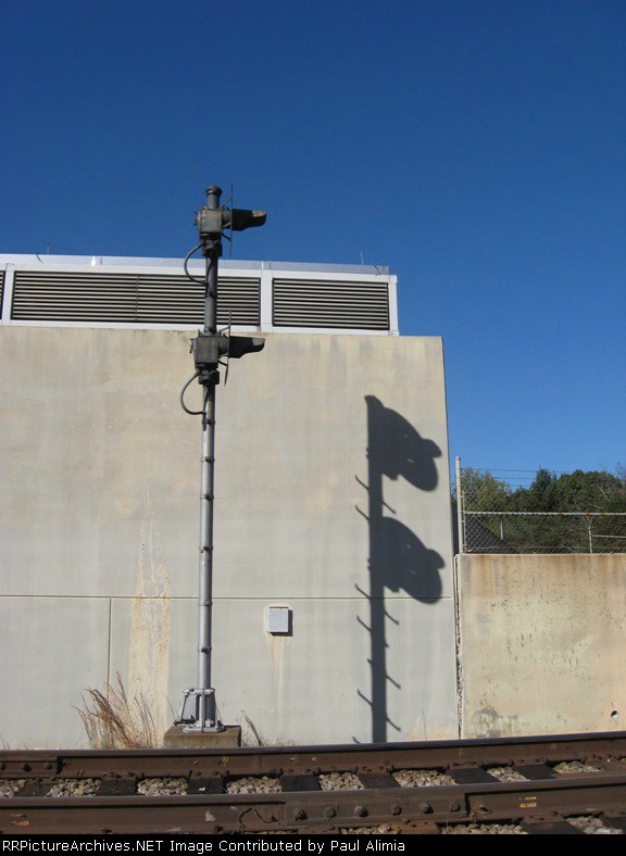 Double searchlight signals see their own shadows next to East Lake MARTA station.