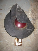 Light from a crossing gate found in the weeds along the tracks