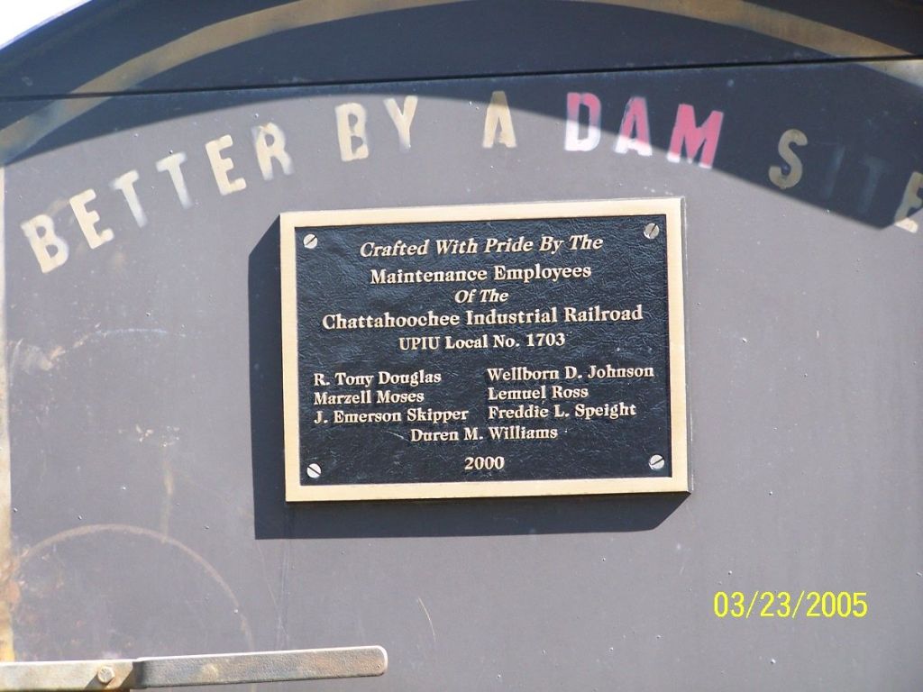 Plaque on back of grill built by CIRR employees.  The grill resembles a steam locomotive and also displays the CIRR's clever slogan, Better by a dam site.  Seen