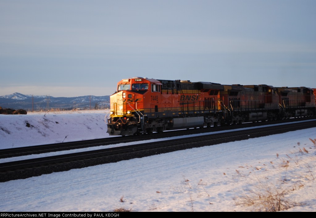 BNSF 7448 rolls east with the Z-SEA-CHI intermodal train at sunrise as the sun reflects of the Swoosh logo.