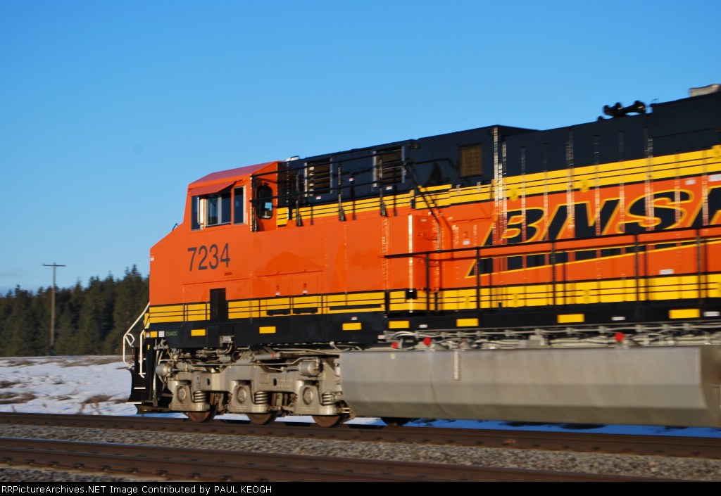Zipping by me at 70 mph BNSF 7234 reflects her new BNSF Swoosh logo in the early aa sun as she rolls west.
