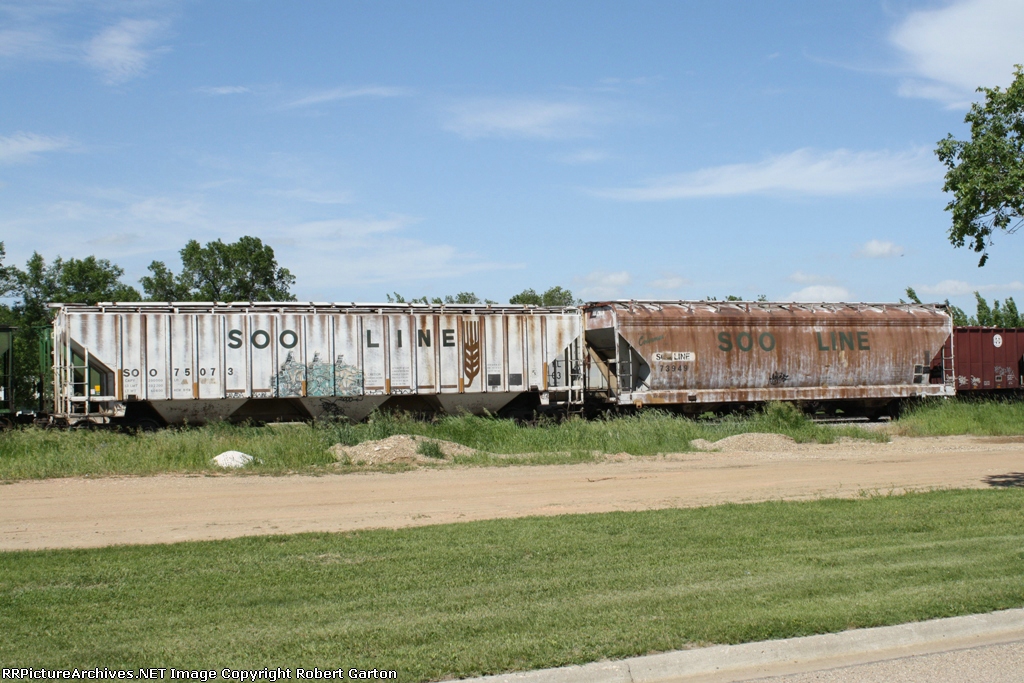 A Pair of Vastly Different SOO Line Covered Hoppers Near the New Century Ag Elevators