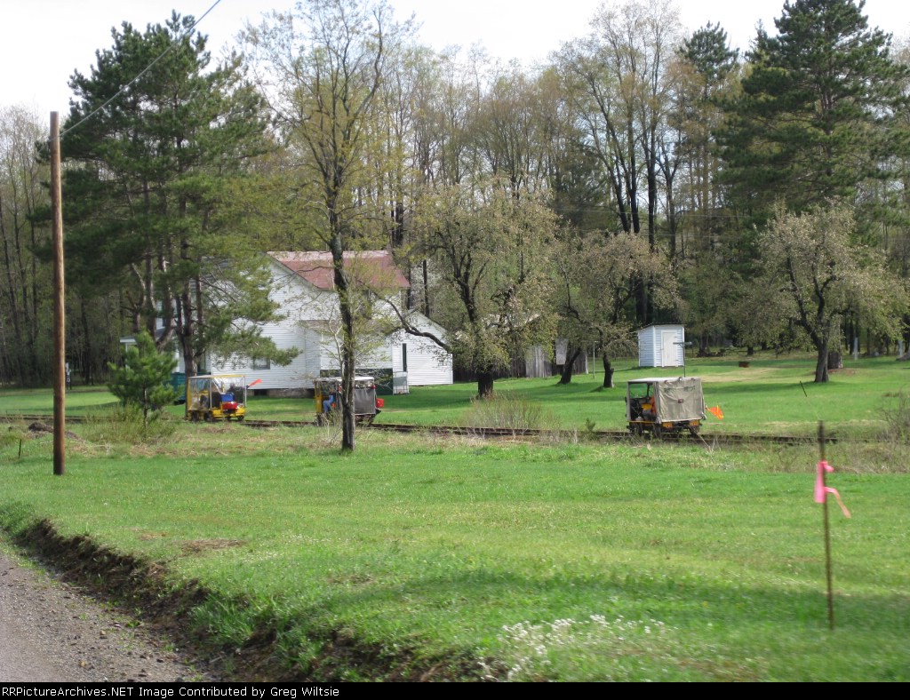 The cars make their way past some houses