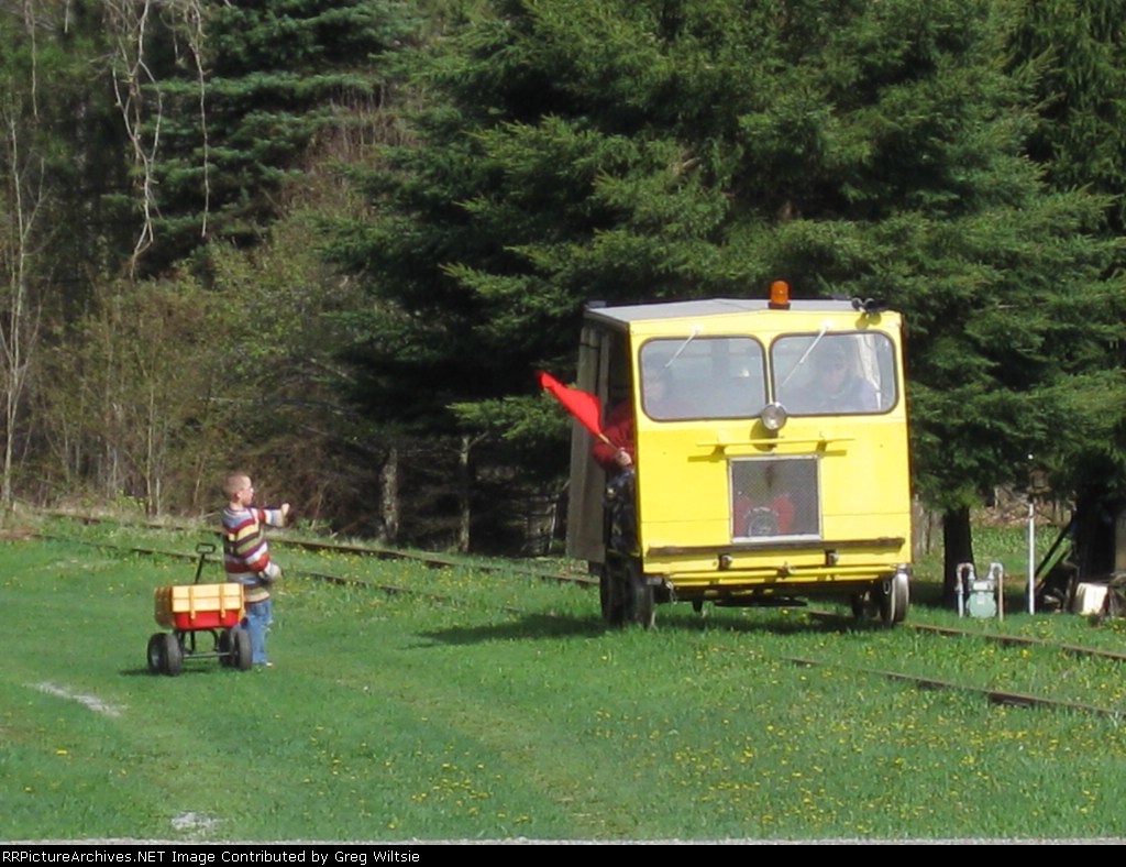 A young boy gets a wave from one of the passing speeders