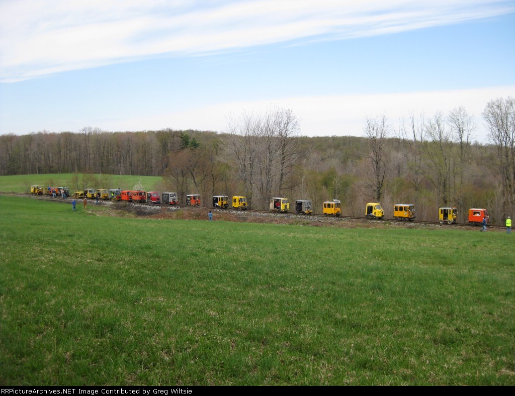 The gwoup of speeders stop in a field near Carlson while one car that broke an axle is looked at