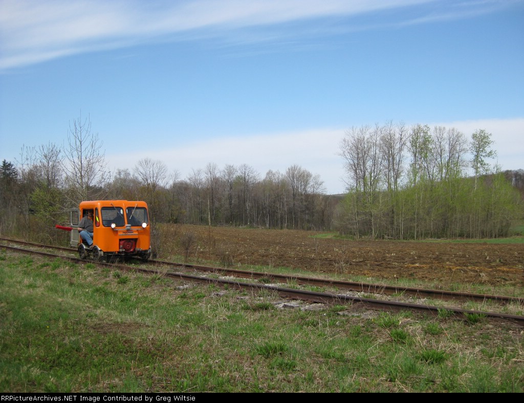 The car with the broken axle is being moved towards a crossing so that it can be moved off the tracks