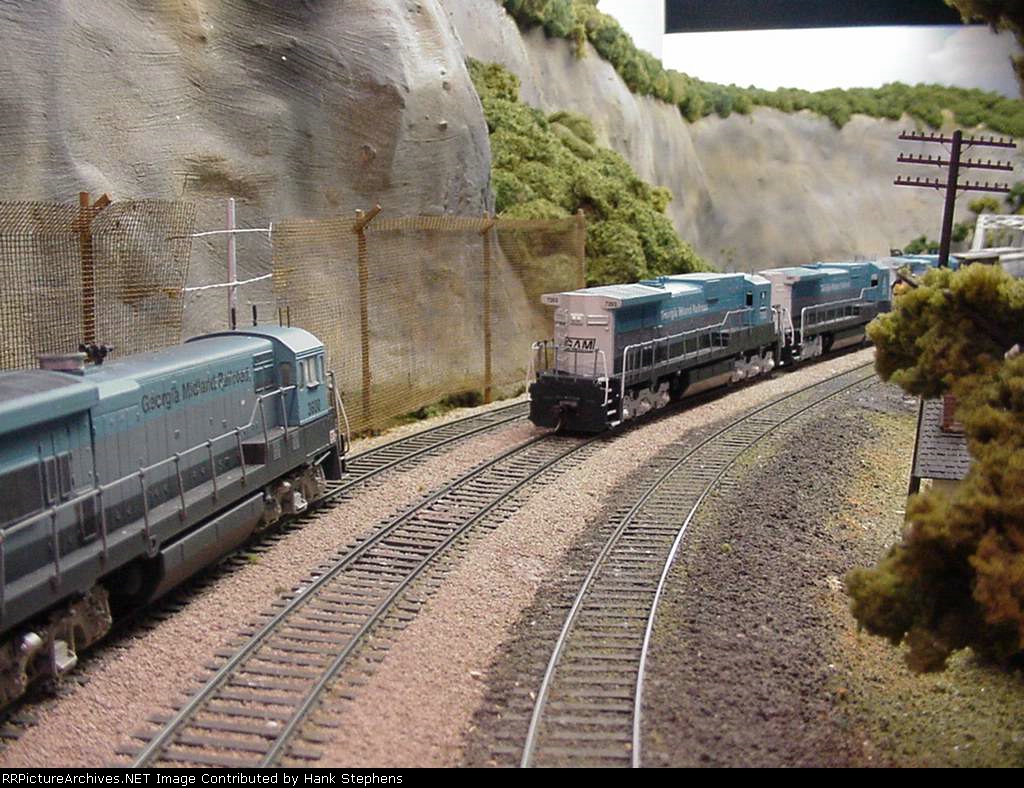 Picture Ten--The GAM time freight finally makes Birmingham on its NS Detour, while a southbound GAM train waits its turn.  Bet the engineer in the northbound wishes he could get a lead unit running short hood forward from the waiting train but the NS Birm