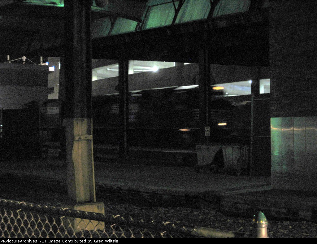 A NS freight makes its way through the Amtrak station just before the Capitol Limited leaves