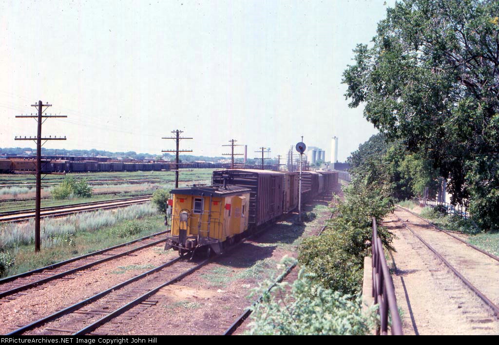 1014-17 Westbound C&NW freight passes MILW Bass Lake Yard