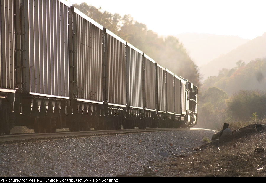 An empty hoppper train races into the afternoon sun, having just departedn Roanoke