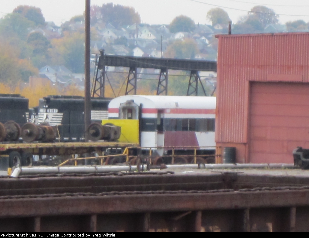 An old passenger car peeks out from behind the business car building