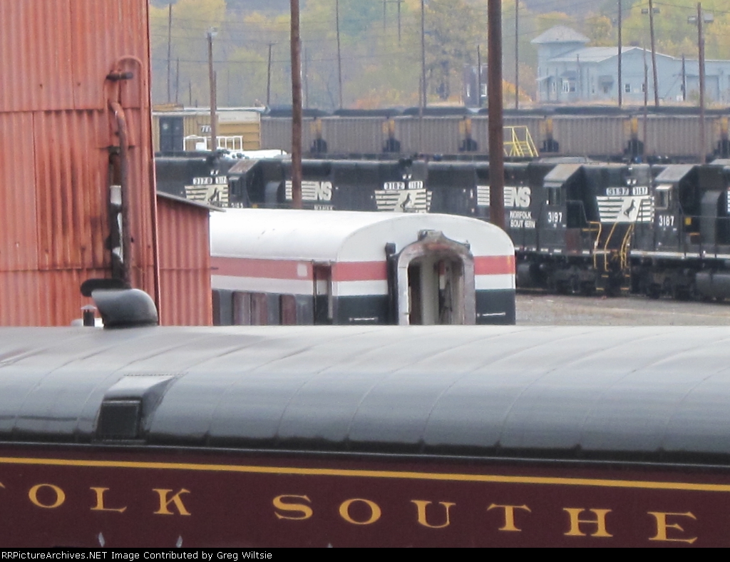 An old passenger car peeks out from behind the business car building