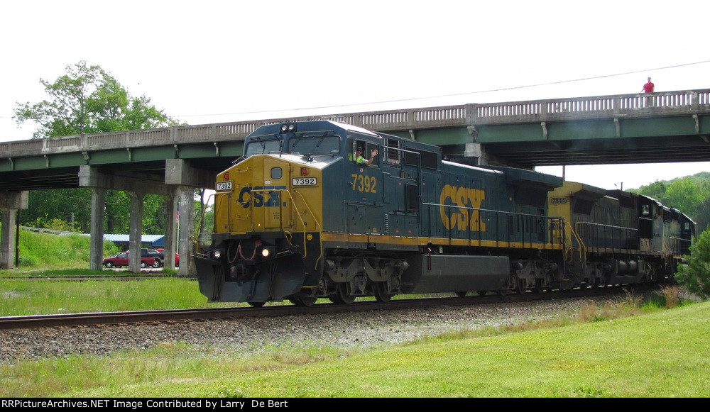 A conducter/father waving goodbye to his young boys. He won't see them for the next 36 hours