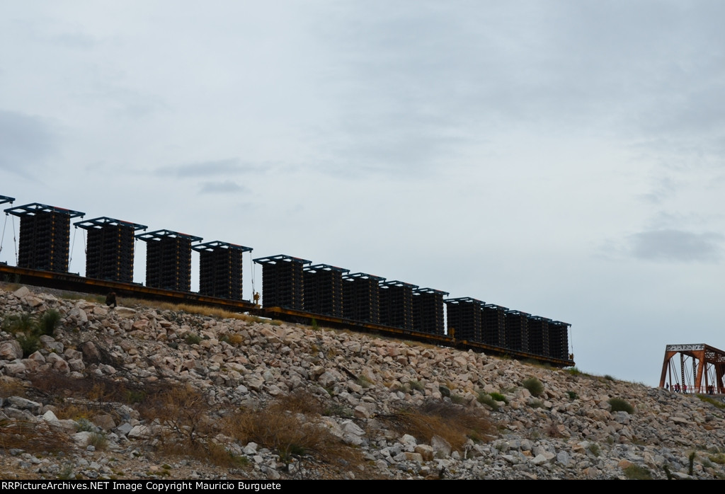 Flatcars for truck chassis passing by the Dam