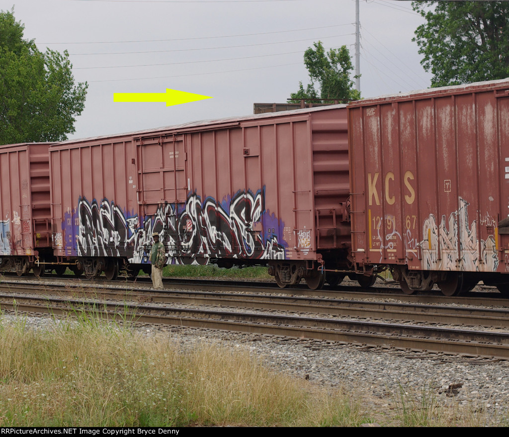 KCS train moves by pedestrian who is paying no attention (except to me)