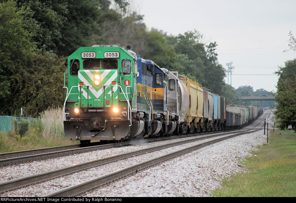 An eastbound CP train with leased power approaches the Metra station and the entrance to Bensenville yard
