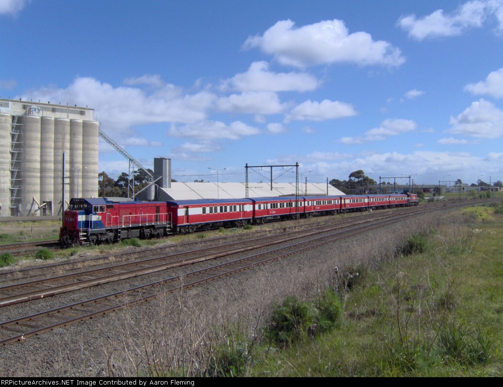 P 12 P25 push pulling a passenger train past the grain silo's