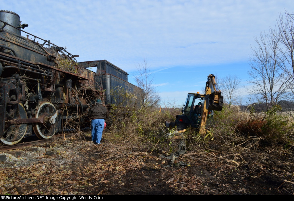 Brush is cleared away from the side of the engine.